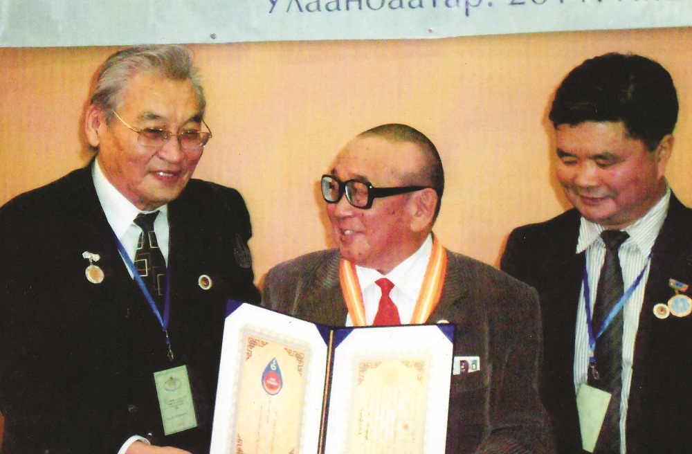 Монгол Улсад Шинжлэх ухааны байгууллага үүсэн бий болсны 90 жилийн ойгоор ШУА-ийн Хэл шинжлэлийн хүрээлэнгийн хүндэт докторын "Алтан гэрэгэ" гардан авч байгаа нь. Зураг дээр: Академич Д.Төмөртогоо, Доктор, Профессор Э.Пүрэвжав нарын хамт